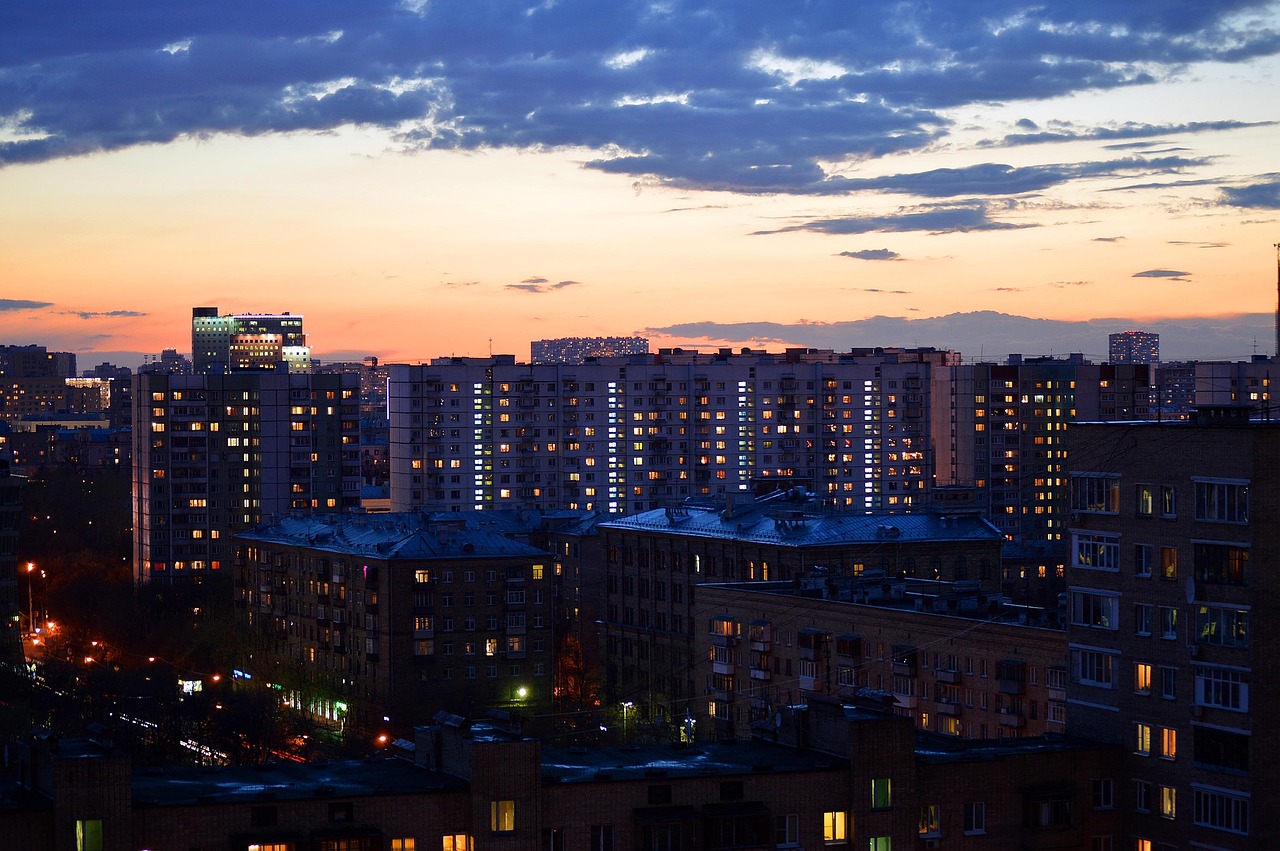 A residential skyline at dusk with the windows of thousands of homes lit up